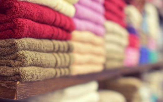 Håndklæder i mange farver stablet på hylde